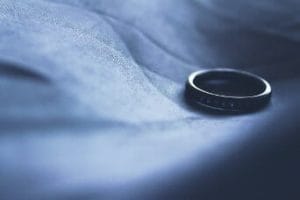 A discarded wedding ring lying on a blue cloth, indicating a divorce.